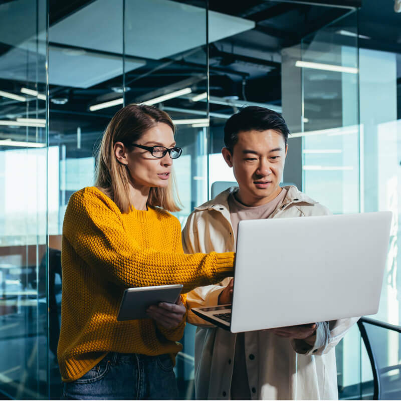 Two Data & AI professionals discussing something on a laptop screen